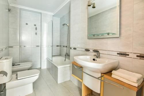 a white bathroom with a sink and a toilet at Gala Centro Modern I in Torrevieja