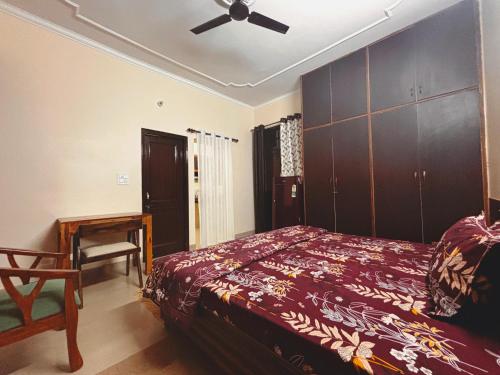a bedroom with a bed and a ceiling fan at The Bel - Monte Stays in Panchkula
