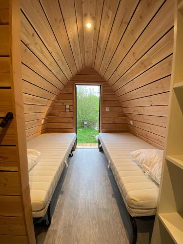a room with two beds in a room with a window at Domaine de l'Ours / Camping Lodge in Saint-Urcize