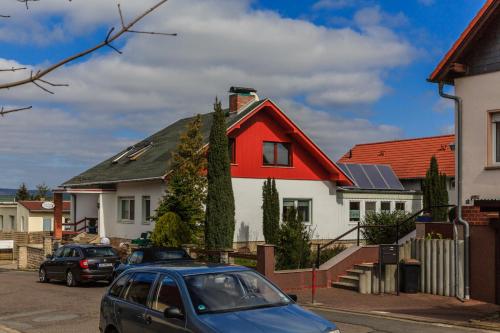 a blue car parked in front of a red and white house at Hotel-Pension am Rosarium in Sangerhausen