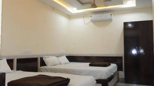 a hotel room with two beds and a fan at Hotel vasaavi Rameswaram in Rāmeswaram