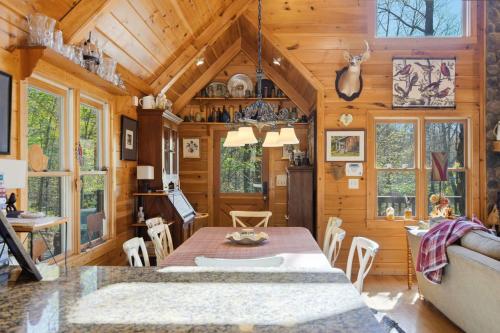 a dining room and living room of a log cabin at Not Your Average Bear Hot Tub in Blue Ridge