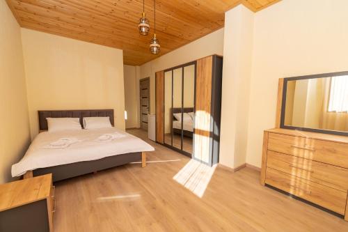 a bedroom with a bed and a dresser at Hotel Chateau Ochia in Koromkhet'i