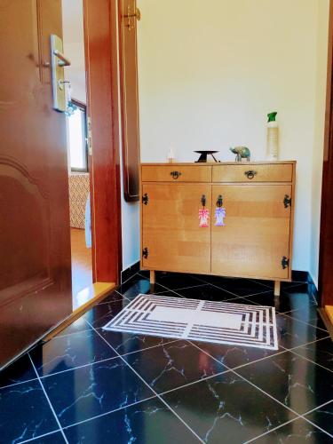 a room with a dresser and a black tile floor at Apartment Green Garden in Sarajevo