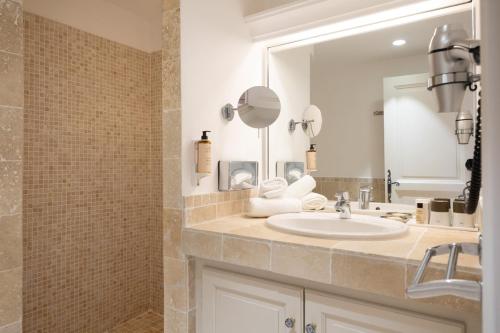 a bathroom with a sink and a mirror at Hotel La Garbine in Saint-Tropez