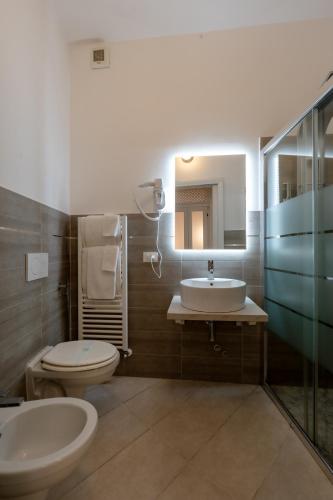 a bathroom with a sink and a toilet and a mirror at Gold Apartment in Ferrara