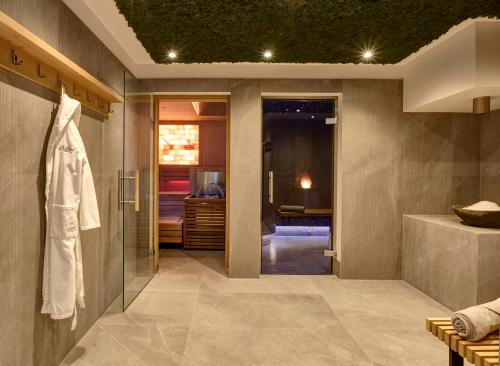 a bathroom with a walk in shower and a sink at Hotel Alpenhof in Bad Wiessee