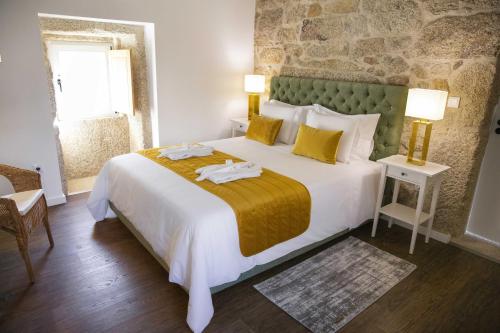 a bedroom with a large bed with two towels on it at Casas de Selim in Arcos de Valdevez