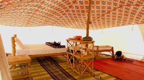 a room with a bed and an umbrella at Etoile du Désert de Lompoul in Kébémèr