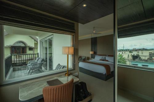 a hotel room with a bed and a balcony at Hotel Tea County in Dibrugarh