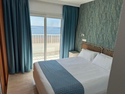 a bedroom with a bed and a view of the ocean at Bahía Serena in Roquetas de Mar
