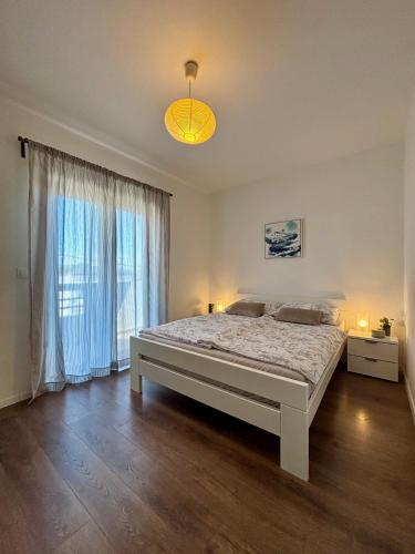 a bedroom with a bed and a large window at Marija in Posedarje