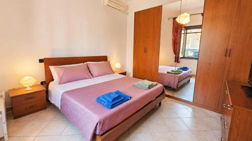 a bedroom with a large bed and a mirror at Casa Are in Oristano