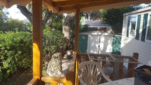 a screened in porch with a table and a grill at Mobilhome Rico in Gassin