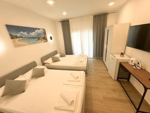 a hotel room with two beds and a television at TWINS Apartments in Bregvija