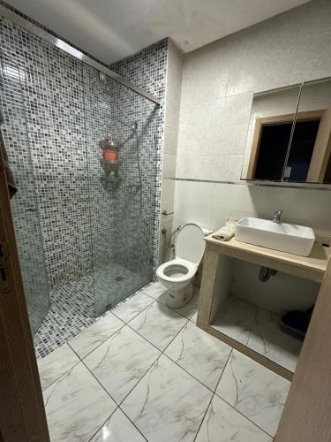 a bathroom with a shower and a toilet and a sink at Apparemment TAMARIS in Dar Bouazza
