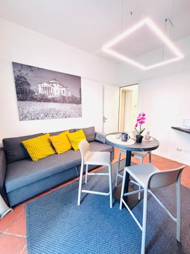 a living room with a couch and a table and chairs at Private Terrace Cozy Flat near Vicenza Center in Vicenza