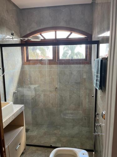 a bathroom with a shower and a toilet and a sink at Chácara com Piscina in Poços de Caldas