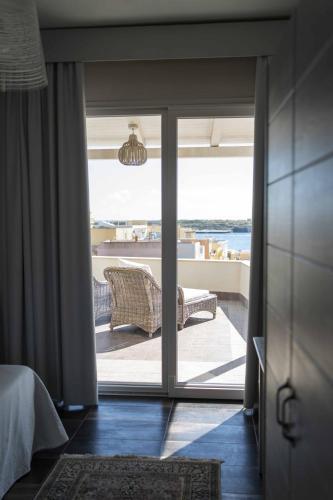 a room with a sliding glass door with a view of the ocean at Hotel Sole in Lampedusa