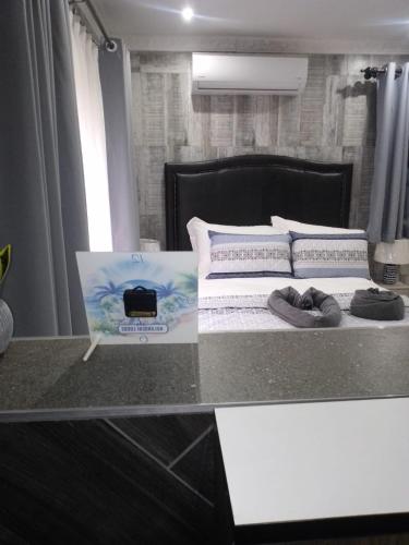 a bedroom with a bed and a table with a magazine at Nolangeni Lodge in Margate