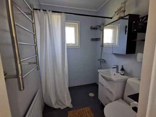 a bathroom with a white shower curtain and a sink at Villa Orreforshult in Orrefors