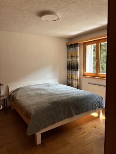 a bedroom with a bed and a window at Ferienwohnung Haus Ginseng in Davos