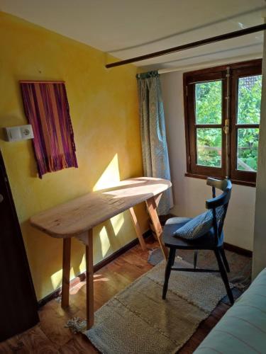 a table in a room with a chair and a window at Bota Rota Pilgrim House in Paredes de Coura