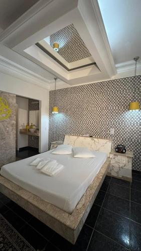 a bedroom with a large white bed in a room at Motel Marajas Mococa - Apartamento 03 in Mococa