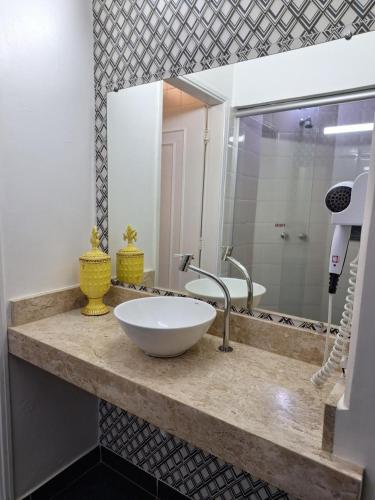 a bathroom counter with a sink and a mirror at Motel Marajas Mococa - Apartamento 03 in Mococa
