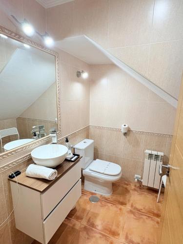 a bathroom with a sink and a toilet and a mirror at Golden Vedra Residences in Pontevedra