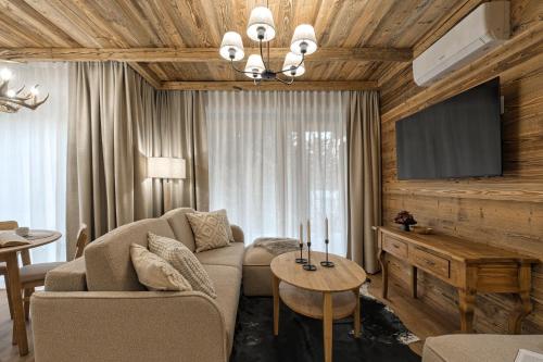 a living room with a couch and a tv at Black Mountain Residence & SPA, Odkryj-Białkę in Białka Tatrzańska