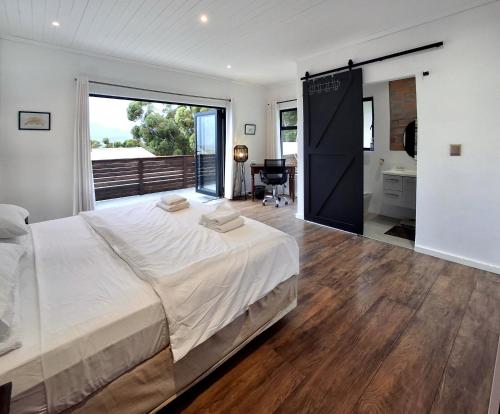 a bedroom with a large bed and a bathroom at Getaway between the sea and the mountains in Gordonʼs Bay
