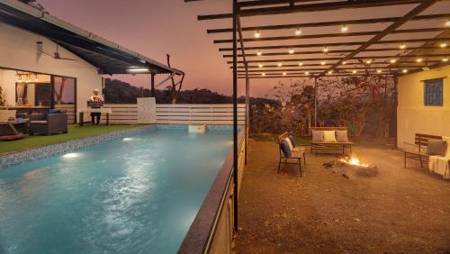 a swimming pool in the backyard of a house at SaffronStays Ivy Courtyard - 5 bedroom & Veg Only Villa in Khopoli in Jambhulpāda