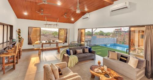 a living room with a couch and a table at SaffronStays Ivy Courtyard - 5 bedroom & Veg Only Villa in Khopoli in Jambhulpāda