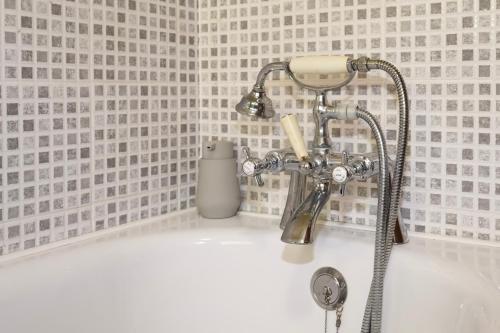 a shower head on a sink in a bathroom at Ardmara in Belladrum