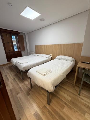 a hospital room with two beds and a table at Bearan Rooms 2 in Pamplona