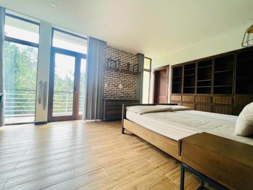a bedroom with a large bed and a large window at Lan Anh Villas Resort in Da Lat