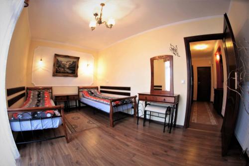 a room with two beds and a table and a mirror at Apartament Morawka in Stronie Śląskie