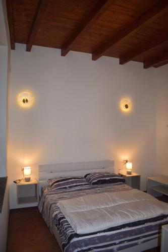 a bedroom with a bed with two lights on the wall at Il Loft Arona Centro, Le Dimore del Corso in Arona