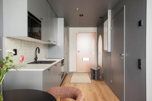 a kitchen with a sink and a table with chairs at Aarni Property in Jyväskylä