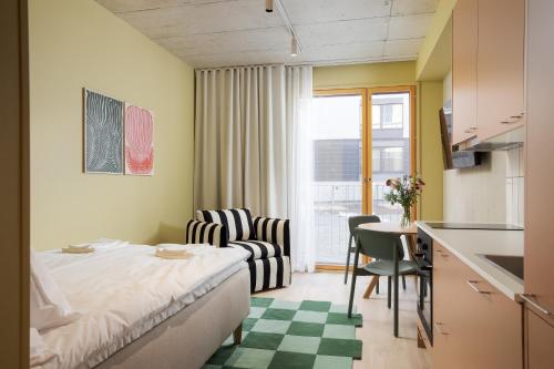 a small hotel room with a bed and a kitchen at Aarni Property in Jyväskylä