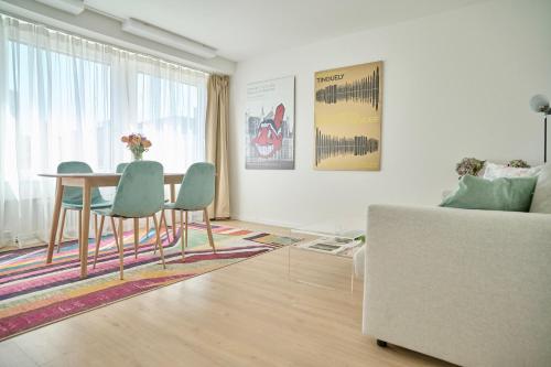 a living room with a table and chairs and a couch at Central rooftop apartment with AC and city view in Basel