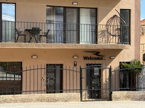 a building with a gate with a welcome sign on it at Relax Boutique House in Kranevo