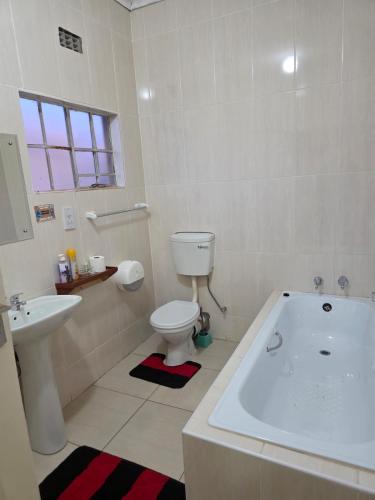 a bathroom with a tub and a toilet and a sink at Rest & Digest in Serowe