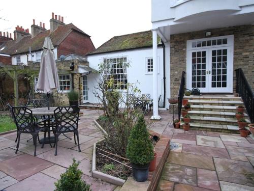 eine Terrasse mit Tisch und Sonnenschirm in der Unterkunft Thanington hotel in Canterbury