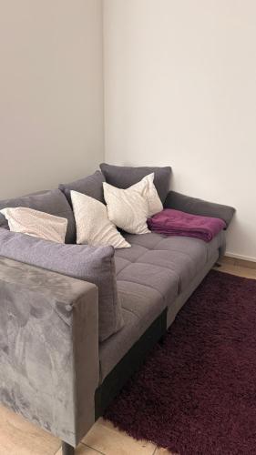 a gray couch with pillows on it in a room at Gemütliche 60m2 Wohnung mit Terasse in Künzing