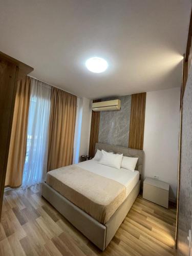 a bedroom with a bed and a large window at Enea Apartments 8 in Tirana