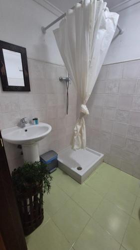 a bathroom with a sink and an umbrella at Casa Senderuela by CARDI Suites in Valdelinares