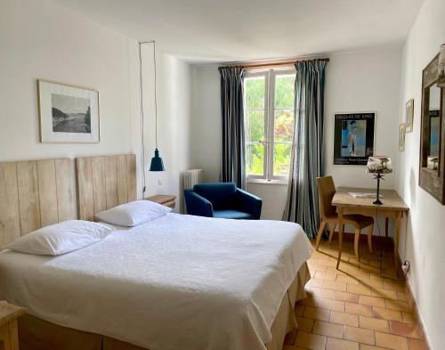 a bedroom with a bed and a desk and a window at Le Manoir de Port-Cros in Port-Cros