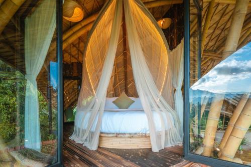 a bedroom in a tree house with mosquito nets at Green Earth Bali luxury Bamboo villas in Sidemen
